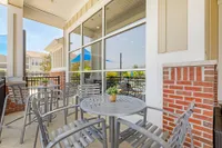 Charming outdoor patio with elegant metal chairs and a small table, perfect for enjoying sunny afternoons.