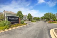 Inviting entrance at Enclave at 127th Apartment Homes featuring lush landscaping, beautiful townhomes, and welcoming atmosphere.