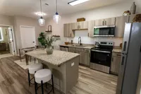 Modern renovated kitchen with granite island, stainless steel appliances and adjacent dining area