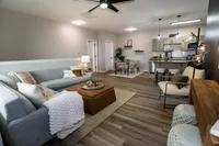 Open-concept living, dining and kitchen area in a renovated Enclave at 127th apartment