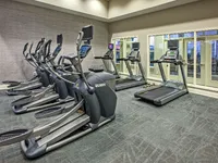 Fitness center featuring treadmills and elliptical machines.