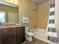 Bathroom with vanity, toilet, and tub/shower with curtain.