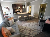 Living Room, Kitchen, and Dining view, with door to utility room revealing full-size washer and dryer.