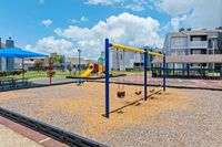 Inviting outdoor playground with swings and slides, nestled within a vibrant apartment community for family-friendly living.