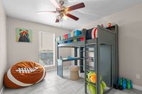 Charming kids' bedroom with a loft bed, colorful decor, and sports-themed touches, perfect for imaginative play.