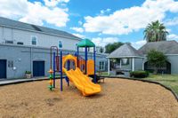 Charming apartment playground with vibrant slides and shady gazebo, ideal for family relaxation and outdoor fun.