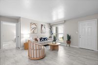 Bright and modern living room with elegant decor, plush seating, and large windows overlooking greenery.