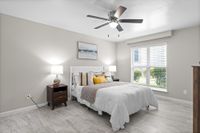 Bright and inviting bedroom with modern decor, large window allowing natural light, and cozy furnishings.