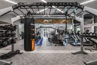 Fitness room with various cardio machines and weights.