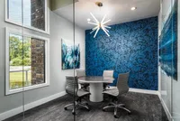 Work room with glass exterior, meeting table that seats next to window. four. Glass modern light fixture hanging from ceiling above the table