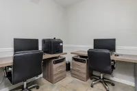Community computer lab with printer, computers, desks, and computer chairs.