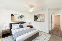 Bedroom with carpet and hardwood floors, wooden furniture set, and a white ceiling fan.