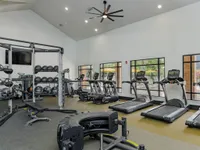 Fitness center with various cardio equipment and weights.