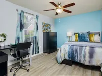 Bedroom with ceiling fan and furniture.