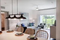 Kitchen with breakfast island, stainless appliances, pendant lights.