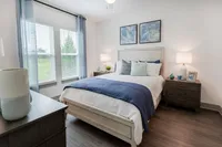 Bedroom with bed, dresser, nightstand.