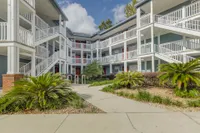 Exterior of the Estates Building. There are three floors, white staircases, red doors, and blue walls.