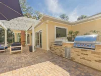 Barbecue area next to the patio seating at the community pool. there are two stainless steel barbecues as well as counter space.