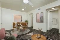 Living area looking into kitchen, breakfast bar with two stools