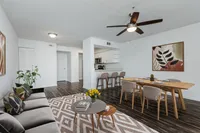 Living area looking into kitchen, breakfast bar with two stools