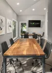 Conference room with two wooden tables and leather chairs. A TV is mounted on the wall.