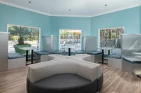 More community study areas showing four restaurant style study booths and a table and chairs in the middle.  Blue accent wall and windows in the background.