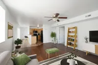 Penthouse living room with couch and tv and kitchen