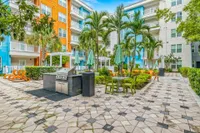 Beautifully landscaped courtyard with plenty of lounge chairs, Italian garden style, string lights.
