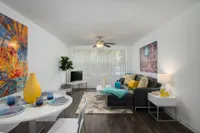 Dining and living room area.  Table and chairs, sofa and chair in background.