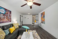Living and dining area with wall mounted television and furnuture.