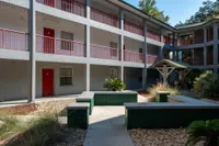 Community exterior with 3 floors, path and small palm trees