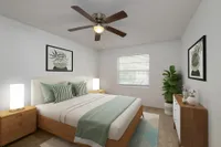 Carpeted bedroom with contemporary furniture, walk in closet, and door to the hallway of the apartment.