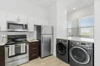 Kitchen with stainless steel appliances and washer dryer