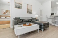 Couch with kitchen and bedroom in background