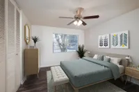 Carpeted bedroom with bed, dresser, nightstand, plant, ceiling fan.