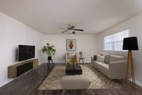 Living area with couch, chairs, television, and ceiling fan.