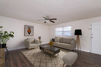 Living area with couch, chairs, television, and ceiling fan.
