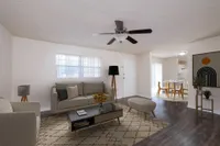 Living area with couch, chairs, television, and ceiling fan.