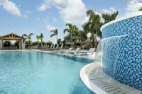 Pool with waterfall and lounge chairs, lanai in background