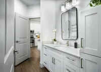 Bathroom with mirror and granite countertop with kitchen in background