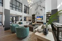 Luxurious modern clubhouse with high ceilings, stylish furniture, and a marble fireplace.
