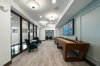 Stylish modern lounge with plush seating, game table, and ambient lighting.