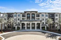 Elegant exterior view of modern Cordova apartments with palm trees and a clear blue sky.