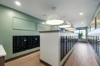 Modern apartment mailroom with stylish lighting and organized mailboxes.