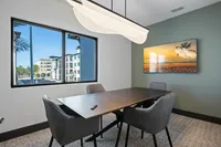 Stylish meeting room with modern furniture and a large window offering a view of contemporary apartments.