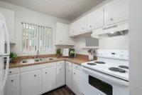Sleek kitchen with white cabinetry, modern appliances, and elegant countertops, inviting a bright and airy atmosphere.