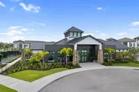 Elegant apartment complex exterior showcasing modern architecture, lush landscaping, and vibrant palm trees under a clear blue sky.