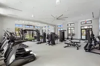 Spacious state-of-the-art fitness center with modern equipment, abundant natural light, and sleek design.