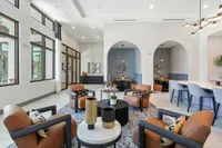 Luxurious open-concept lounge area with modern seating, stylish decor, and expansive windows inviting warm natural light.