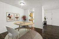 Chic dining area featuring a modern round table set for two, artistic wall decor, and an inviting kitchen with warm wooden cabinetry.